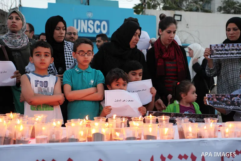 Palestinians light candles during a protest two days after at least 60 Palestinians were killed and 2,400 were injured including children, were shot and killed by Israeli soldiers as they gathered to demonstrate along th...