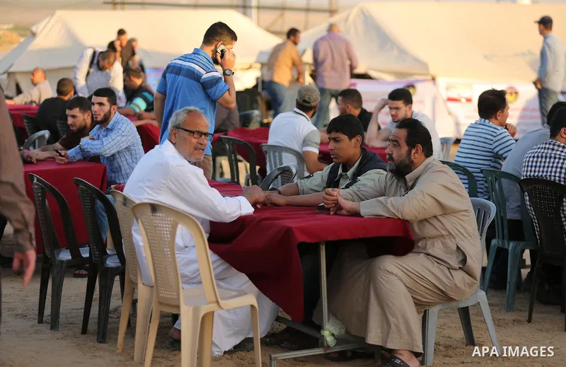 Palestinian muslims prepare to break their fast on the holy fasting month of Ramadan, at the Israel-Gaza border, in east of Gaza city, on May 17, 2018. Ramadan is sacred to Muslims because it is during that month that tr...