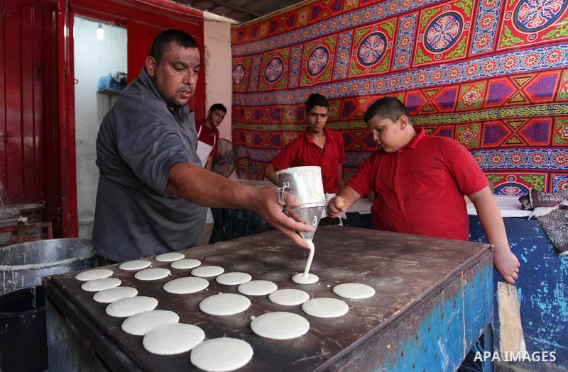 A Palestinian vendor prepares "Qatayef", traditional pancakes that are popular during the Muslim fasting month of Ramadan, at a market in Gaza city on May 19, 2018. Ramadan is sacred to Muslims because it is during that...