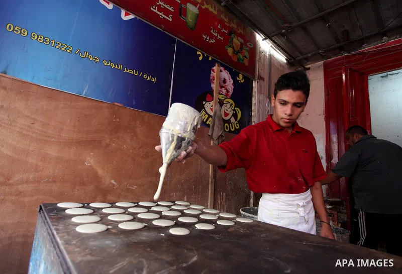A Palestinian vendor prepares "Qatayef", traditional pancakes that are popular during the Muslim fasting month of Ramadan, at a market in Gaza city on May 19, 2018. Ramadan is sacred to Muslims because it is during that...