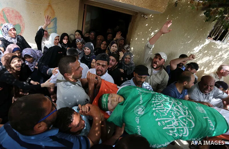 Mourners carry the body of Palestinian Mohammed Alian, 20, who died of wounds he sustained during clashes with Israeli troops in a tent city protest where Palestinians demand the right to return to their homeland and aga...