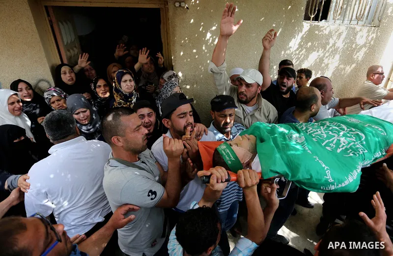 Mourners carry the body of Palestinian Mohammed Alian, 20, who died of wounds he sustained during clashes with Israeli troops in a tent city protest where Palestinians demand the right to return to their homeland and aga...