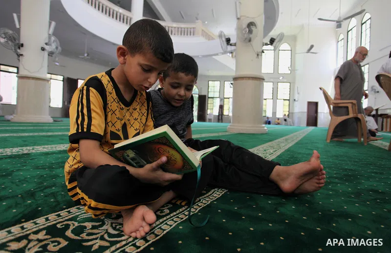 Palestinian boys read the Koran, Islam's holiest book, at a mosque in Gaza City on the Muslim holy month of Ramadan, on May 20, 2018. Ramadan is sacred to Muslims because it is during that month that tradition says the K...