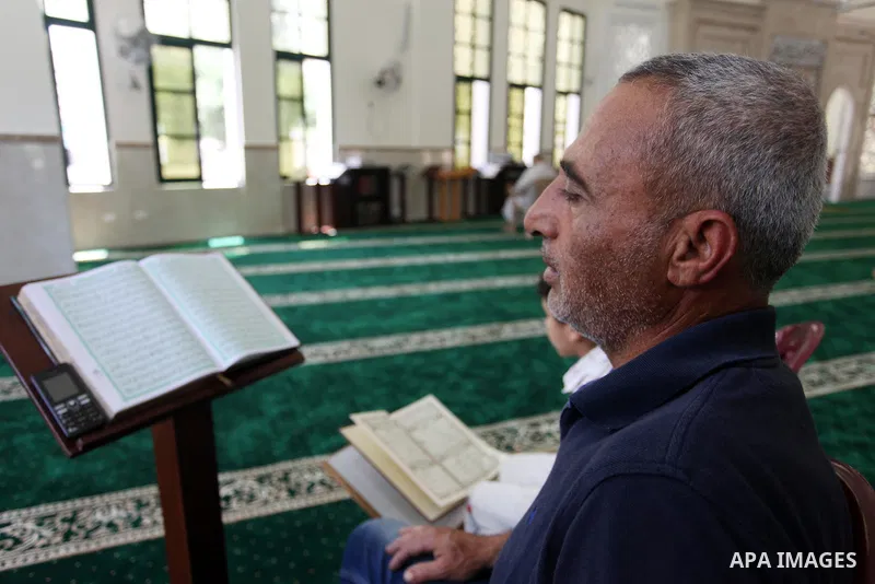 A Palestinian man and his boy read the Koran, Islam's holiest book, at a mosque in Gaza City on the Muslim holy month of Ramadan, on May 20, 2018. Ramadan is sacred to Muslims because it is during that month that traditi...