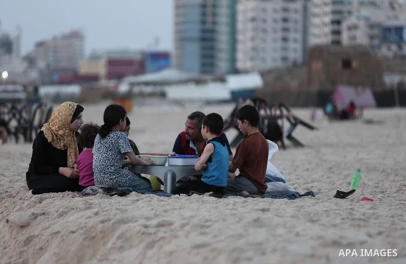 A Palestinian family gathers at the beach to break their fast during the Muslim Holy month of Ramadan, in Gaza City, on May 21, 2018. Ramadan is sacred to Muslims because it is during that month that tradition says the K...