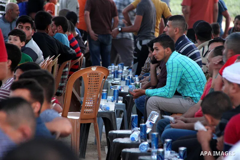 Palestinians wait to break their fast on the Muslim holy fasting month of Ramadan at the Israel-Gaza border, in east of Gaza city, on May 23, 2018. Ramadan is sacred to Muslims because it is during that month that tradit...