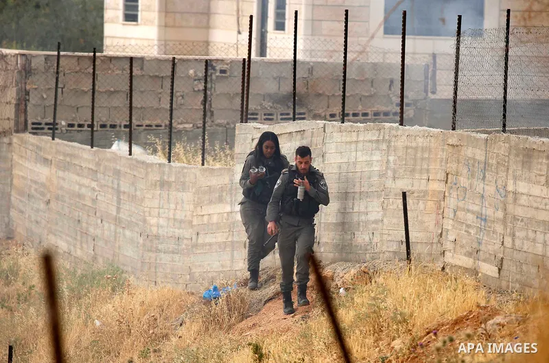 Israeli policemen stand guard as Palestinians try to make their way to attend the second Friday prayer of the holy fasting month of Ramadan in Jerusalem's Al-Aqsa mosque, after Israeli police prevented them from crossing...