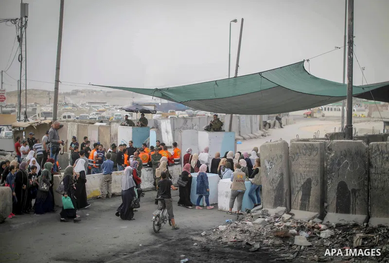 Palestinians make their way through Qalandia checkpoint to attend the second Friday prayer of the holy fasting month of Ramadan in Jerusalem's Al-Aqsa mosque, near Ramallah in the occupied West Bank, on May 25, 2018. Ram...