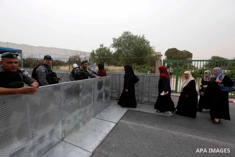Palestinians make their way through an Israeli checkpoint to attend the second Friday prayer of the holy fasting month of Ramadan in Jerusalem's Al-Aqsa mosque, in Bethlehem in the occupied West Bank, on May 25, 2018. Ra...