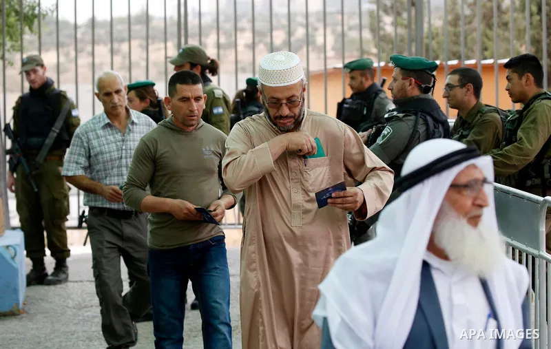Palestinians make their way through an Israeli checkpoint to attend the second Friday prayer of the holy fasting month of Ramadan in Jerusalem's Al-Aqsa mosque, in Bethlehem in the occupied West Bank, on May 25, 2018. Ra...