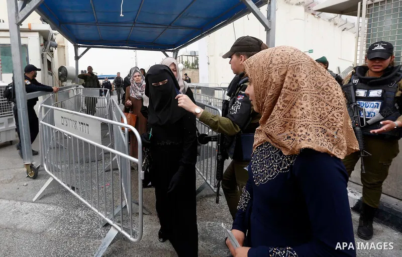 Palestinians make their way through an Israeli checkpoint to attend the second Friday prayer of the holy fasting month of Ramadan in Jerusalem's Al-Aqsa mosque, in Bethlehem in the occupied West Bank, on May 25, 2018. Ra...