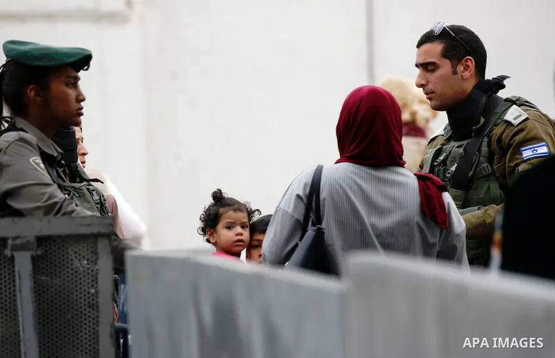 Palestinians make their way through an Israeli checkpoint to attend the second Friday prayer of the holy fasting month of Ramadan in Jerusalem's Al-Aqsa mosque, in Bethlehem in the occupied West Bank, on May 25, 2018. Ra...