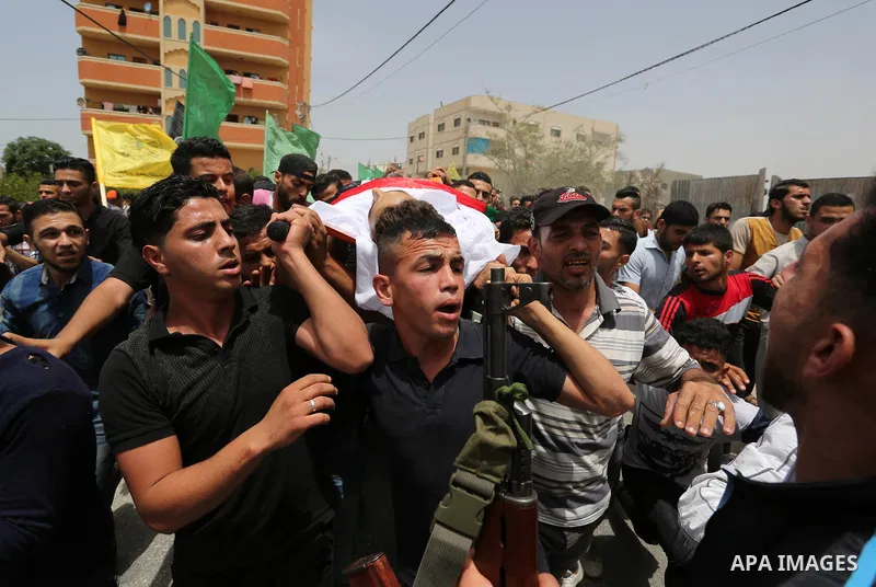 Palestinian mourners carry the body of Ahmed Qutoosh, 23, who died of his wounds endured during clashes with Israeli troops in a tent city protest where Palestinians demand the right to return to their homeland at the Is...
