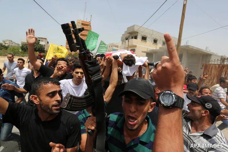 Palestinian mourners carry the body of Ahmed Qutoosh, 23, who died of his wounds endured during clashes with Israeli troops in a tent city protest where Palestinians demand the right to return to their homeland at the Is...