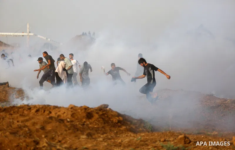 Palestinian protesters gather during clashes with Israeli security froces in a tent city protest where Palestinians demand the right to return to their homeland and against U.S. embassy move to Jerusalem at the Israel-Ga...