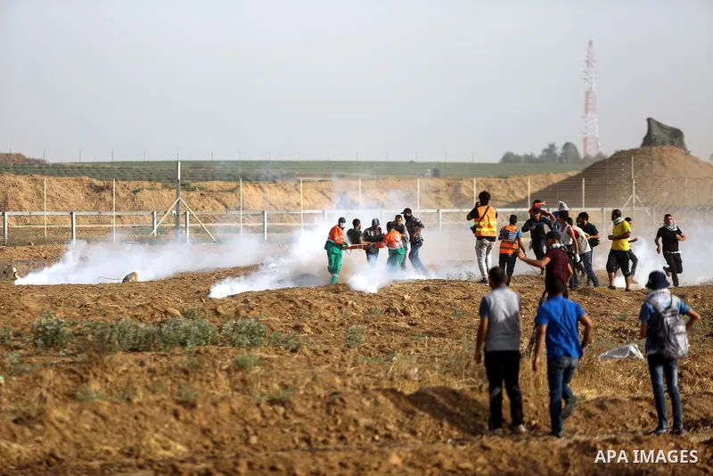 Palestinian protesters gather during clashes with Israeli security froces in a tent city protest where Palestinians demand the right to return to their homeland and against U.S. embassy move to Jerusalem at the Israel-Ga...
