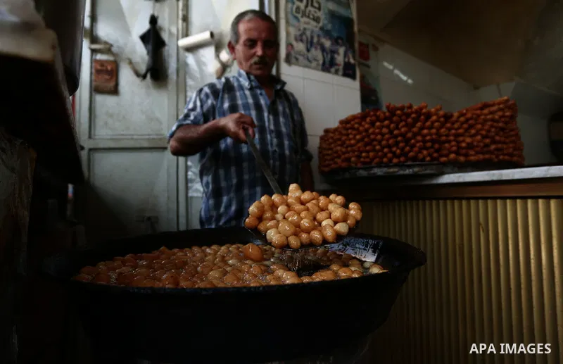 A Palestinian vendor prepares sweets at a market during the holy month of Ramadan in the West Bank city of Nablus on May 26, 2018. Ramadan is sacred to Muslims because it is during that month that tradition says the Kora...