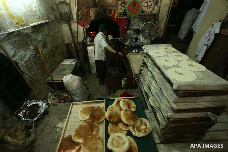 A Palestinian vendor prepares bread during the holy month of Ramadan in the West Bank city of Nablus on May 26, 2018. Ramadan is sacred to Muslims because it is during that month that tradition says the Koran was reveale...
