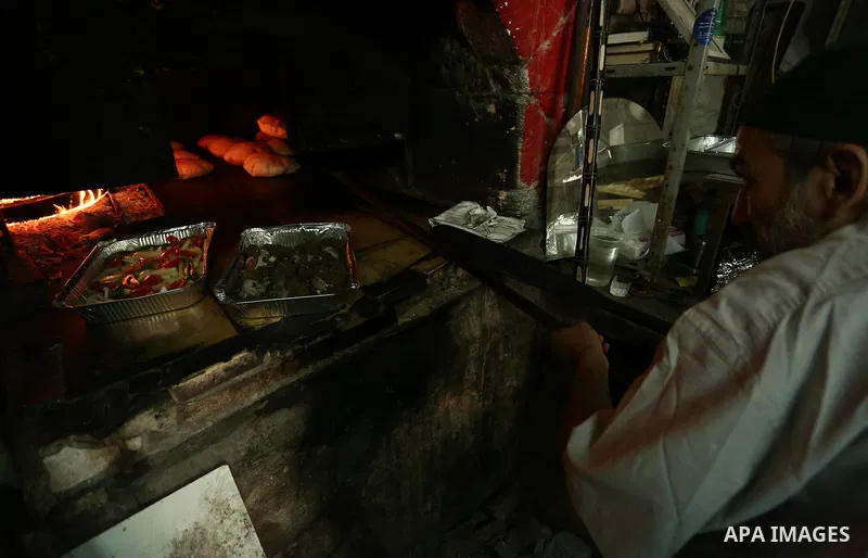 A Palestinian man cooks foods in a traditional oven during the holy fasting month of Ramadan, in the West Bank city of Nablus on May 26, 2018. Ramadan is sacred to Muslims because it is during that month that tradition s...