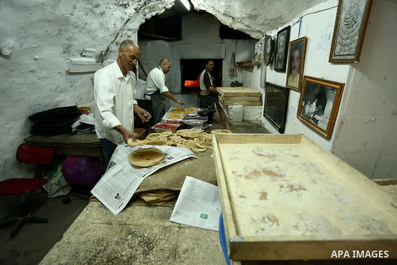 A Palestinian vendor prepares bread during the holy month of Ramadan in the West Bank city of Nablus on May 26, 2018. Ramadan is sacred to Muslims because it is during that month that tradition says the Koran was reveale...
