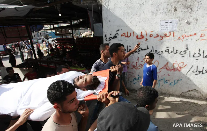 Palestinian mourners carry the body of Nasser al-Arini, 28, who died of his wounds endured during clashes with Israeli troops in a tent city protest where Palestinians demand the right to return to their homeland at the...