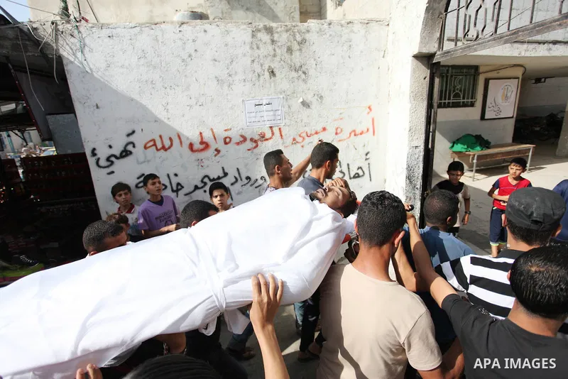 Palestinian mourners carry the body of Nasser al-Arini, 28, who died of his wounds endured during clashes with Israeli troops in a tent city protest where Palestinians demand the right to return to their homeland at the...