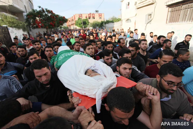 Palestinian mourners carry the body of Mohammed al-Radee, 25, who was killed in Israeli tank fire during his funeral, in Beit Lahia in the northern of Gaza Strip on May 28, 2018. Photo by Mahmoud Ajour