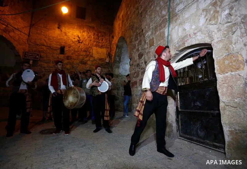 Palestinians "dawn awakener" or Al Musaharati in Arabic, wake Muslims for their overnight 'sahur', last meal, before the day's fast, as they walk through streets in the old city of the West Bank city of Hebron just befor...
