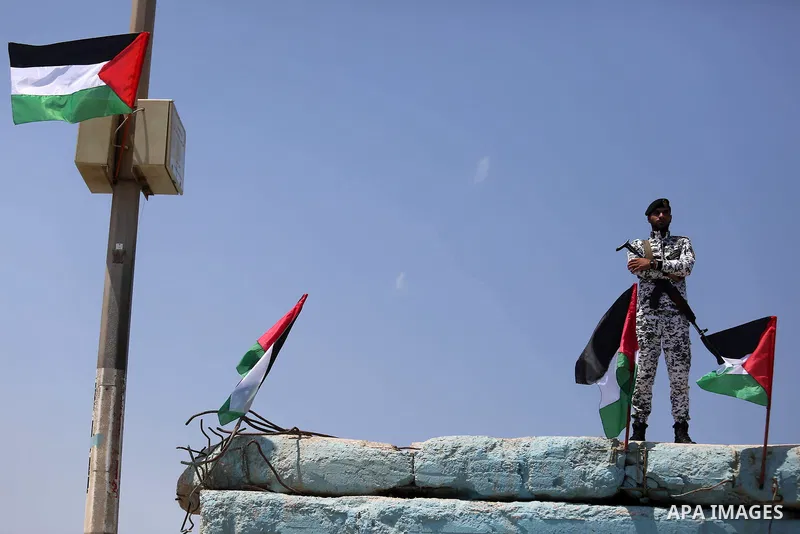 A member of Palestinian security forces stands guard as Palestinian activists ride fishing boats as they protesting and perhaps trying to breach Israel's naval blockade on Gaza, setting to sail from Gaza City harbour tow...