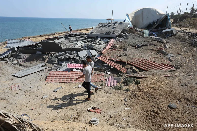 Palestinians walk near the site targeted by an Israeli air strike, in Khan younis in the southern Gaza strip, May 30, 2018. The Israeli Defense Forces said it launched more than 35 airstrikes targeting the militant group...