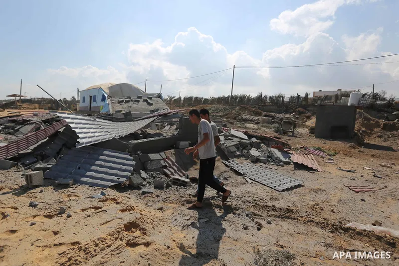 Palestinians walk near the site targeted by an Israeli air strike, in Khan younis in the southern Gaza strip, May 30, 2018. The Israeli Defense Forces said it launched more than 35 airstrikes targeting the militant group...