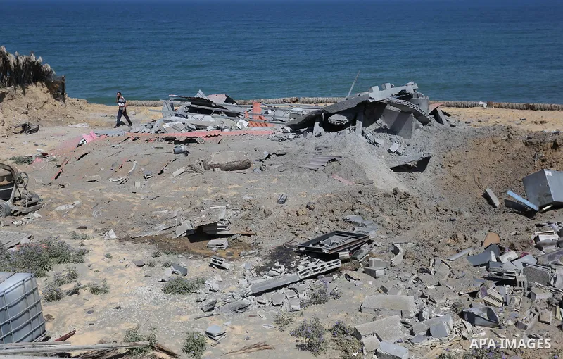 A Palestinian man inspects the site targeted by an Israeli air strike, in Khan younis in the southern Gaza strip, May 30, 2018. The Israeli Defense Forces said it launched more than 35 airstrikes targeting the militant g...