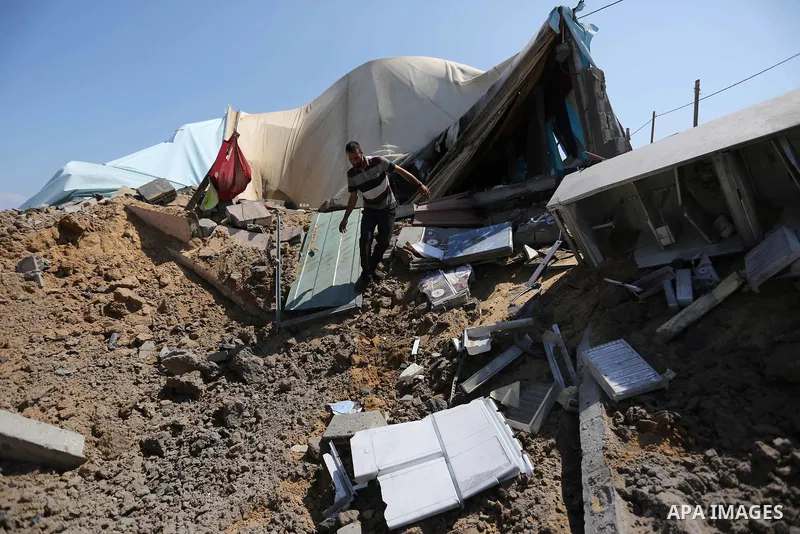 A Palestinian man inspects the site targeted by an Israeli air strike, in Khan younis in the southern Gaza strip, May 30, 2018. The Israeli Defense Forces said it launched more than 35 airstrikes targeting the militant g...