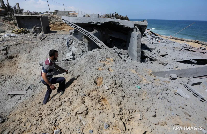A Palestinian man inspects the site targeted by an Israeli air strike, in Khan younis in the southern Gaza strip, May 30, 2018. The Israeli Defense Forces said it launched more than 35 airstrikes targeting the militant g...
