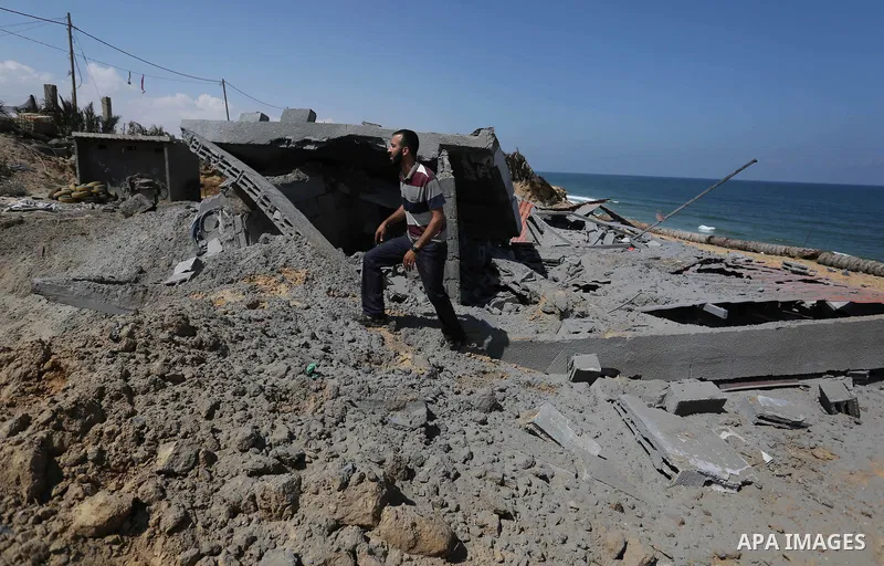 A Palestinian man inspects the site targeted by an Israeli air strike, in Khan younis in the southern Gaza strip, May 30, 2018. The Israeli Defense Forces said it launched more than 35 airstrikes targeting the militant g...