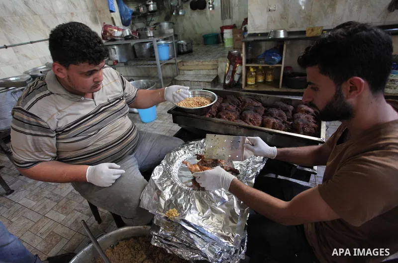 Palestinians prepare rice and chickens as they wait for customers several hours before Iftar, the breaking of the day long Ramadan fast in Gaza City, on May 30, 2018. Muslims around the world refrain from eating, drinkin...