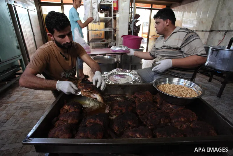 Palestinians prepare rice and chickens as they wait for customers several hours before Iftar, the breaking of the day long Ramadan fast in Gaza City, on May 30, 2018. Muslims around the world refrain from eating, drinkin...