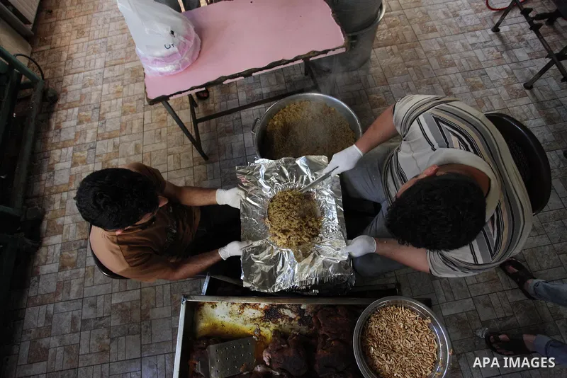 Palestinians prepare rice and chickens as they wait for customers several hours before Iftar, the breaking of the day long Ramadan fast in Gaza City, on May 30, 2018. Muslims around the world refrain from eating, drinkin...