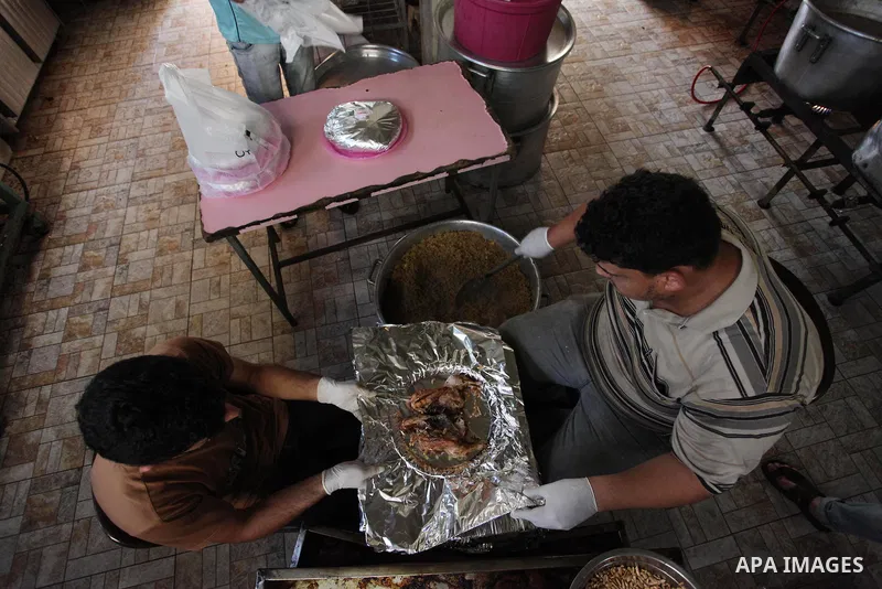 Palestinians prepare rice and chickens as they wait for customers several hours before Iftar, the breaking of the day long Ramadan fast in Gaza City, on May 30, 2018. Muslims around the world refrain from eating, drinkin...