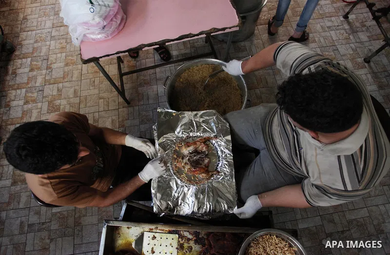Palestinians prepare rice and chickens as they wait for customers several hours before Iftar, the breaking of the day long Ramadan fast in Gaza City, on May 30, 2018. Muslims around the world refrain from eating, drinkin...