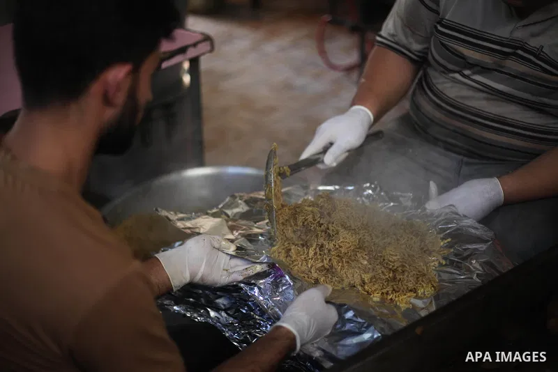 Palestinians prepare rice and chickens as they wait for customers several hours before Iftar, the breaking of the day long Ramadan fast in Gaza City, on May 30, 2018. Muslims around the world refrain from eating, drinkin...
