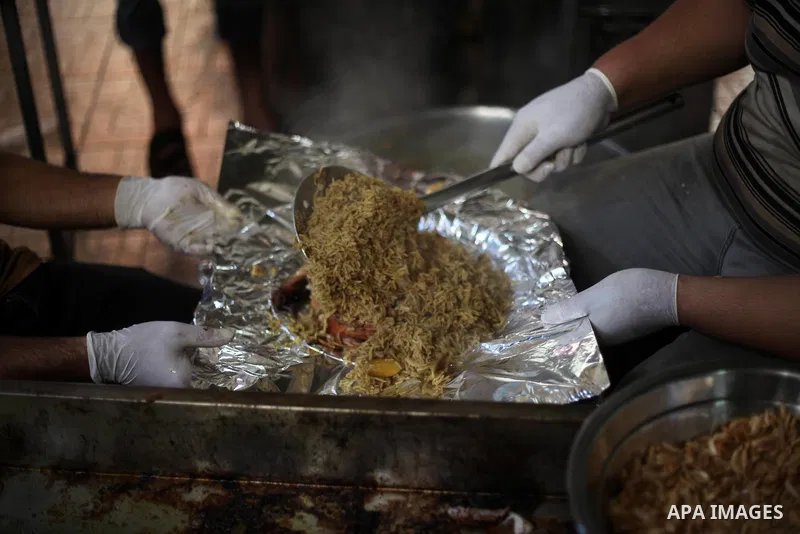 Palestinians prepare rice and chickens as they wait for customers several hours before Iftar, the breaking of the day long Ramadan fast in Gaza City, on May 30, 2018. Muslims around the world refrain from eating, drinkin...