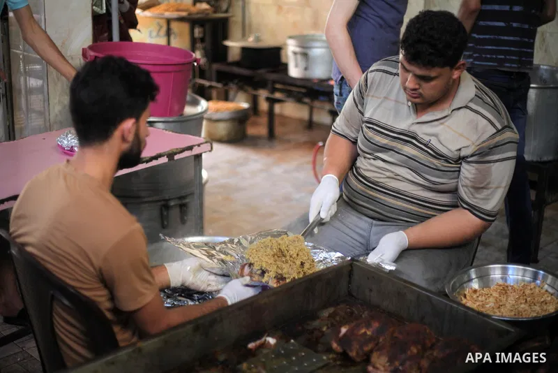 Palestinians prepare rice and chickens as they wait for customers several hours before Iftar, the breaking of the day long Ramadan fast in Gaza City, on May 30, 2018. Muslims around the world refrain from eating, drinkin...