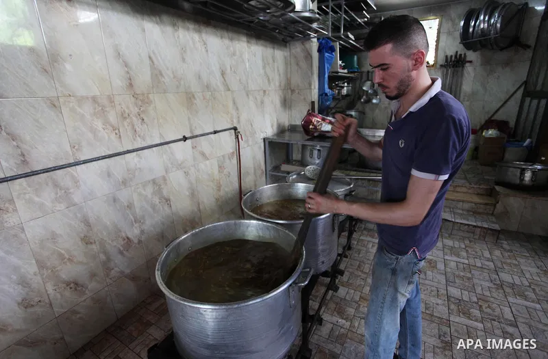 Palestinians prepare rice and chickens as they wait for customers several hours before Iftar, the breaking of the day long Ramadan fast in Gaza City, on May 30, 2018. Muslims around the world refrain from eating, drinkin...