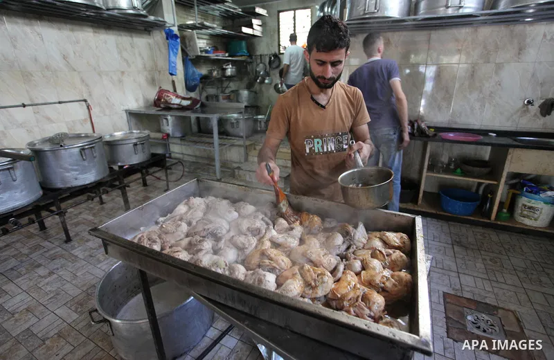 Palestinians prepare rice and chickens as they wait for customers several hours before Iftar, the breaking of the day long Ramadan fast in Gaza City, on May 30, 2018. Muslims around the world refrain from eating, drinkin...