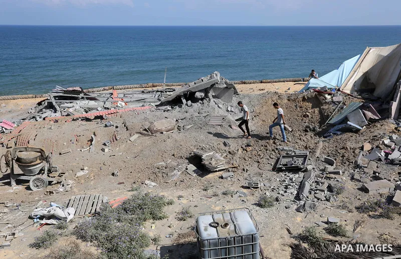 Palestinians inspect the site targeted by an Israeli air strike, in Khan younis in the southern Gaza strip, May 30, 2018. The Israeli Defense Forces said it launched more than 35 airstrikes targeting the militant groups...