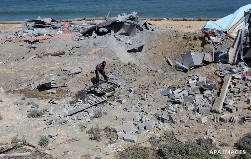Palestinians inspect the site targeted by an Israeli air strike, in Khan younis in the southern Gaza strip, May 30, 2018. The Israeli Defense Forces said it launched more than 35 airstrikes targeting the militant groups...