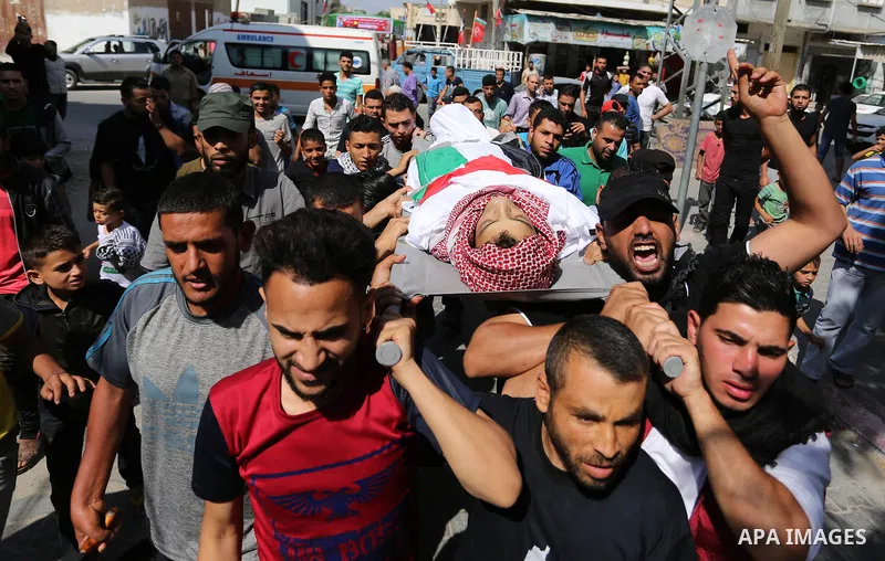 Mourners carry the body of Palestinian Naji Ghneim, 23, who died of his wounds endured during clashes with Israeli troops in a tent city protest where Palestinians demand the right to return to their homeland at the Isra...