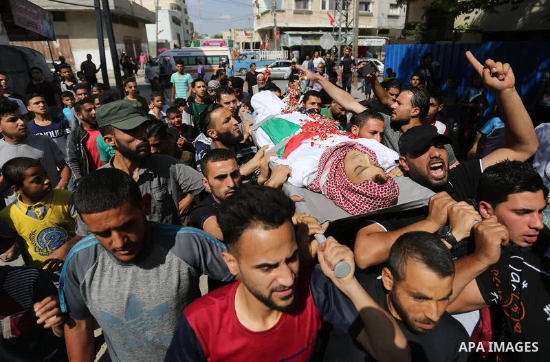 Mourners carry the body of Palestinian Naji Ghneim, 23, who died of his wounds endured during clashes with Israeli troops in a tent city protest where Palestinians demand the right to return to their homeland at the Isra...