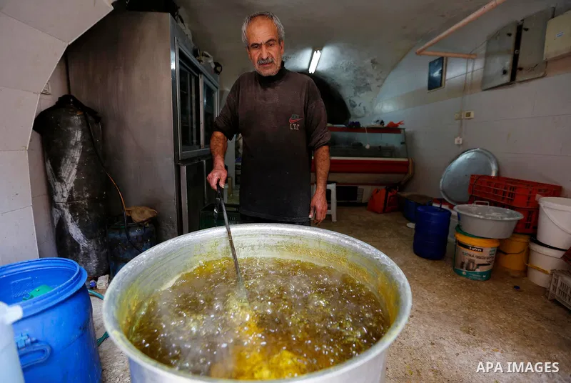A Palestinian vendor prepares sweets at a market during the holy fasting month of Ramadan in the West Bank city of Hebron, May 30, 2018. Ramadan is sacred to Muslims because it is during that month that tradition says th...